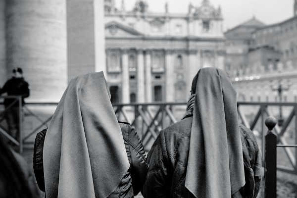 Women wear scarfs outside the Basilica, in the Vatican City, Rome